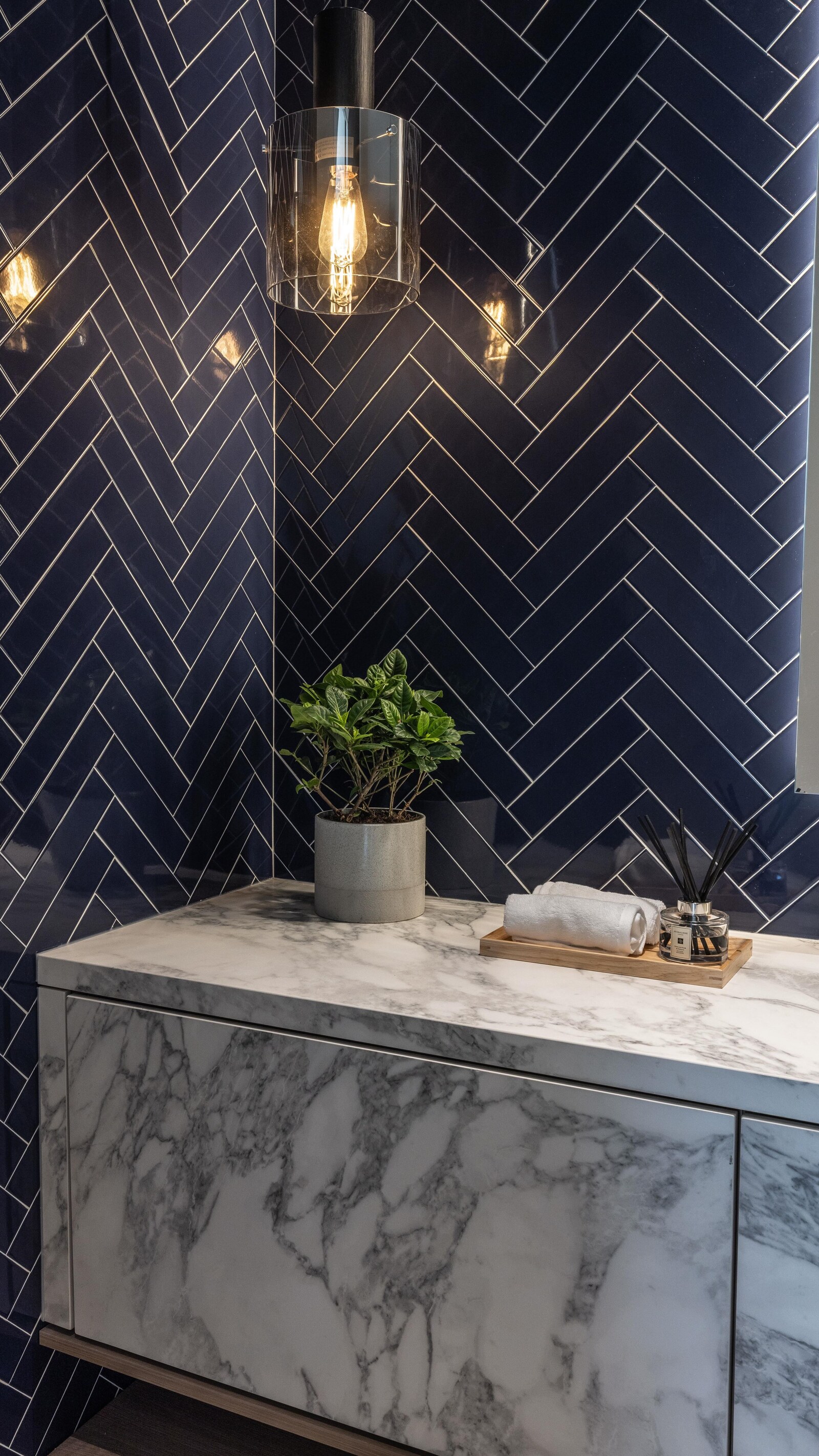 Luxury powder room with precisely aligned navy herringbone tile
